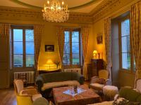 a living room with a couch and chairs and a chandelier at B&amp;B Château de Preuil in Vallenay