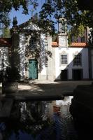 a building with a green door and a clock tower at Parador Casa Da Insua in Penalva do Castelo