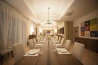 ein langer Esstisch mit weißen Stühlen und ein Kronleuchter in der Unterkunft Feudo Del Biviere in Santa Ninfa