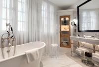 a white bathroom with a tub and a sink at Hôtel Richer De Belleval - Relais &amp; Châteaux in Montpellier