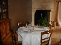 a table with a white table cloth and a fireplace at Le Relais du Lyon d&#39;Or in Angles-sur-lʼAnglin