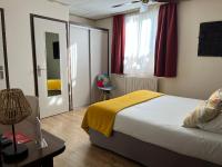 a bedroom with a bed with a yellow blanket on it at Hôtel L&#39;Iroko The Originals City in Aix-les-Bains