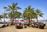 a resort with chairs and umbrellas and palm trees at Amari Phuket in Patong Beach