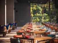 uma longa fileira de mesas e cadeiras de madeira em Avani Plus Khao Lak Resort em Khao Lak
