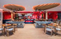 um restaurante com mesas e cadeiras e uma cozinha em Avani Plus Khao Lak Resort em Khao Lak