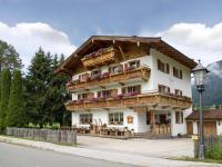 a building in the mountains with flowers on the balconies at Pension Edelweiss in Söll