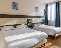 a hotel room with two beds and a window at Hôtel Le Florin in Rennes