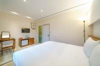 a bedroom with a white bed and a desk at 東風雅舍 in Hualien City