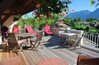 a wooden deck with chairs and a table on a balcony at Amélia Appartement Saint-Jorioz in Saint-Jorioz