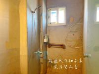 a shower in a bathroom with writing on the wall at Yuzi Homestay in Hualien City