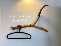 a wooden limb hanging from a wall with a light at Yuzi Homestay in Hualien City