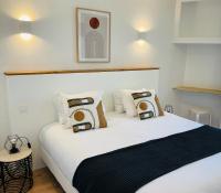 a bedroom with a large white bed with pillows at Hôtel Porte Mars Reims Gare Centre Arena in Reims
