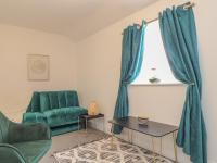 a living room with green chairs and a window at Mews House in Camborne