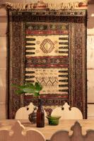 a tapestry hanging on a wall with a table with a plant at Leśniczówka u Zięby in Kościelisko