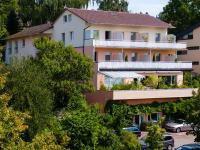 a building with cars parked in a parking lot at Hotel Alpenblick Garni in Überlingen