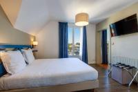 a bedroom with a large bed and a large window at Best Western Hotel De La Plage Saint Marc sur Mer in Saint-Nazaire