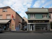 un hombre caminando por la calle delante de una tienda en Charmant Studio à Belfort quartier Vosges, en Belfort