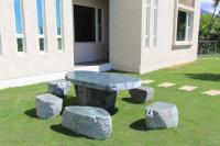 a stone table and four stone stools in the grass at Cai Feng B&amp;B in Ji&#39;an