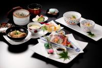 a table with plates of food and bowls of food at Kanazawa Hakuchoro Hotel Sanraku -Natural Hot Spring- in Kanazawa