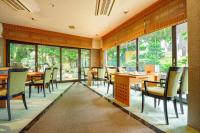 a restaurant with tables and chairs and windows at Kanazawa Hakuchoro Hotel Sanraku -Natural Hot Spring- in Kanazawa
