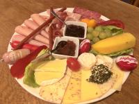 a plate of cheese and other foods on a table at Landlust Hotel in Gransee