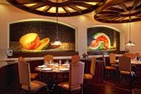 een restaurant met tafels en stoelen en schilderijen aan de muur bij The Royal Haciendas Resort & Spa in Playa del Carmen