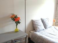 a vase of flowers sitting on a table next to a bed at 2 chambres privées au calme à la Maison des Bambous in Dijon