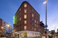 a tall brick building on a city street at night at Bijou Hôtel Paris Boulogne in Boulogne-Billancourt