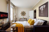 a bedroom with a bed with white sheets and yellow pillows at Cocoon 2 Proche - Disney Paris- Parking gratuit in Serris
