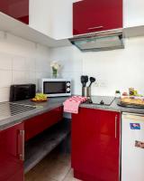 a kitchen with red cabinets and a microwave at Cocoon 2 Proche - Disney Paris- Parking gratuit in Serris