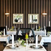a dining room with white tables and chairs and two mirrors at SORAT Insel-Hotel Regensburg in Regensburg