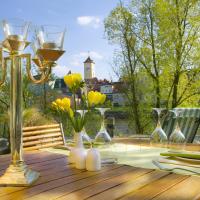 a table with wine glasses and yellow flowers on it at SORAT Insel-Hotel Regensburg in Regensburg