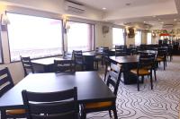 uma sala de jantar cheia de mesas e cadeiras em Jakarta Airport Hotel em Tangerang