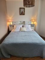 a bedroom with a large bed with a blue comforter at LA P&#39;TITE YPORTAISE in Yport