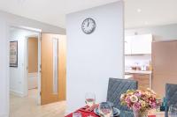 a dining room table with a clock on a wall at City View Apartments Birmingham City Centre in Birmingham