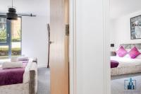 a bedroom with a bed with purple pillows at City View Apartments Birmingham City Centre in Birmingham