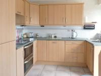 a kitchen with wooden cabinets and a counter top at Joylands in Budock Water