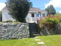 a stone retaining wall in front of a house at Joylands in Budock Water