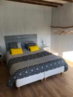 a bedroom with a large bed with yellow pillows at Les Vieille tuiles in Cudos