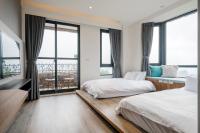 two beds in a room with large windows at Cingjing Florence Resort Villa in Ren&#39;ai