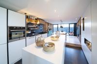 a kitchen with white countertops and a living room at Gîtesdesignemoi entre Design et émotion - la perle in Onhaye
