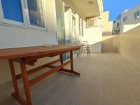 a wooden bench in a room with a table at One Bed Room Apartment with terrace in Marsaskala