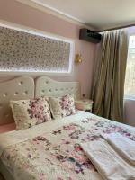 - une chambre dotée d&#39;un lit avec un couvre-lit floral dans l&#39;établissement SPA Apartament Sirius house, à Saints Constantine et Helena