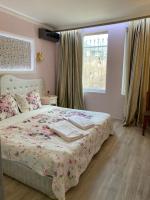 a bedroom with a bed with a floral bedspread and a window at SPA Apartament Sirius house in Saints Constantine and Helena