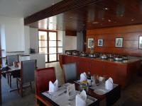 a restaurant with tables and a counter with pots and pans at The Promenade in Puducherry