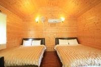two beds in a room with wooden walls at Ji Ji Farm Homestay in Jiji