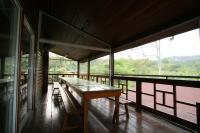 a room with a table and benches on a balcony at Ji Ji Farm Homestay in Jiji