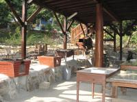 a patio with a stone wall and a wooden structure at Ji Ji Farm Homestay in Jiji