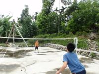 two boys playing a game of tennis on a net at Ji Ji Farm Homestay in Jiji