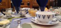 a table with a tea cup and plates and utensils at L Imperatrice in Berck-sur-Mer